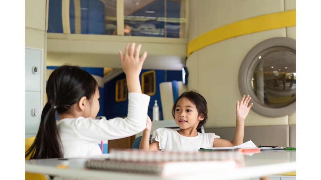 Children raising their hands before answering questions.